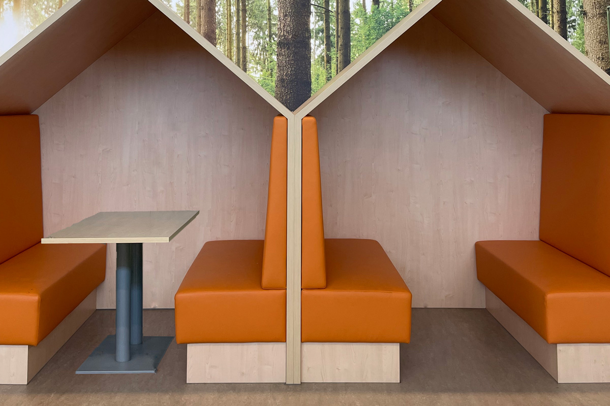 Treinbank op maat met houten werkhuisjes en oranje banken.