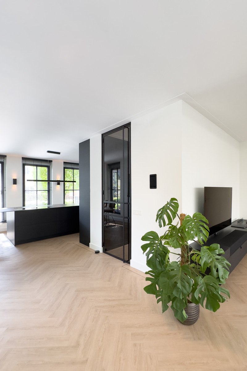 Luxe interieur met zwarte keuken en stalen deur