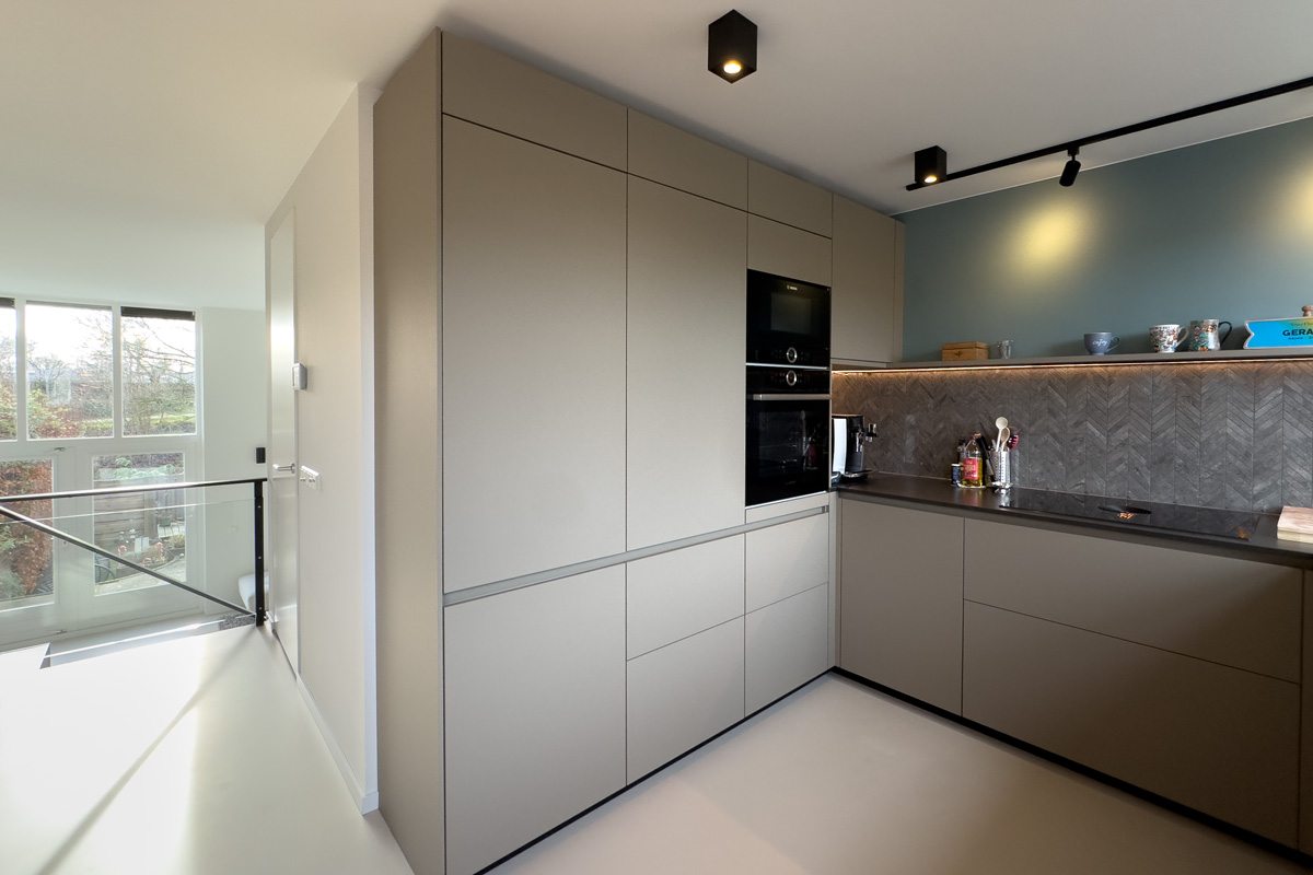 Moderne keuken op maat in Amersfoort met ingebouwde apparatuur, visgraat wandtegels en een luxe, stijlvolle afwerking.