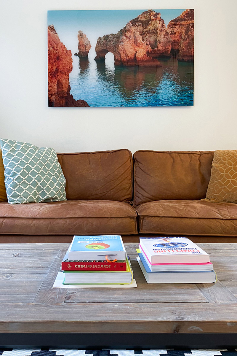 Loungehoek in het kantoorpand van Vasco met boekenkast en fotolijst aan de wand.