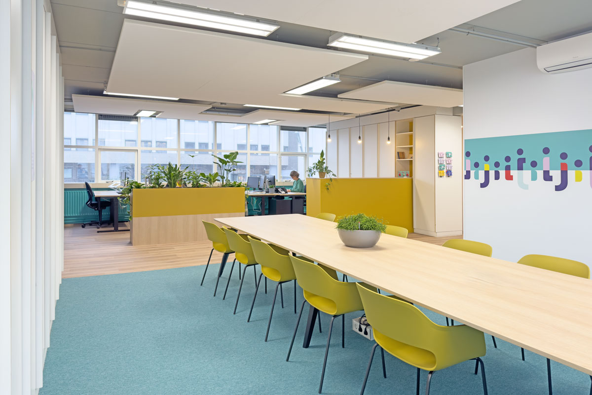 Open kantoortuin met grote vergadertafel in de huisstijl van Staij