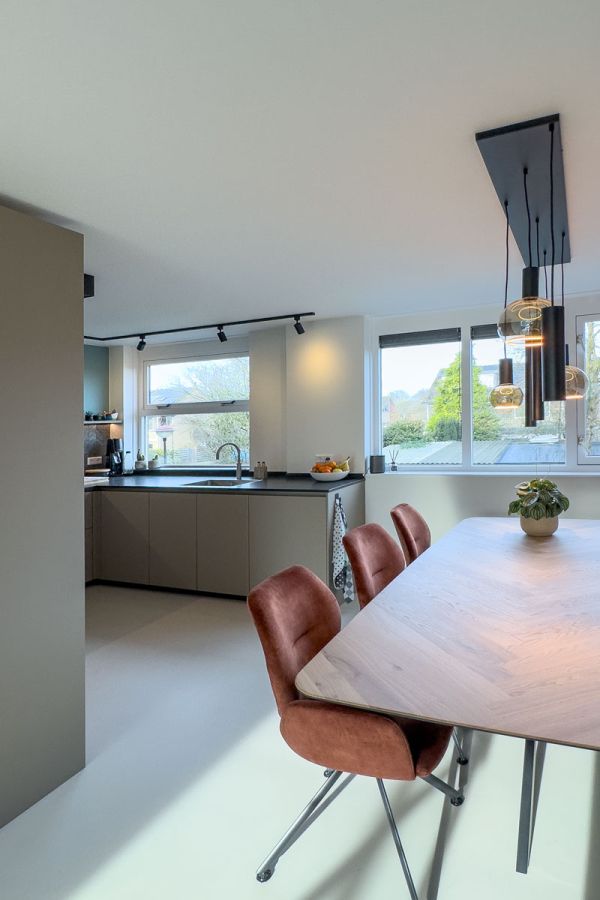 Interieur op maat met een moderne keukeninrichting en stijlvolle eethoek, ontworpen met luxe materialen en veel natuurlijk licht in een woning in Amersfoort.