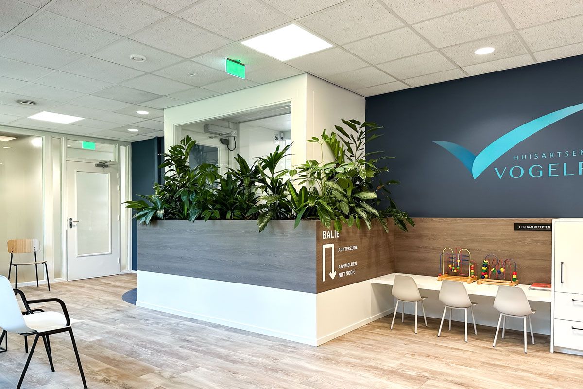 Ombouw van de balie met geïntegreerde plantenbak en kindermeubel in de wachtkamer van Huisartsenpraktijk Vogelplein.