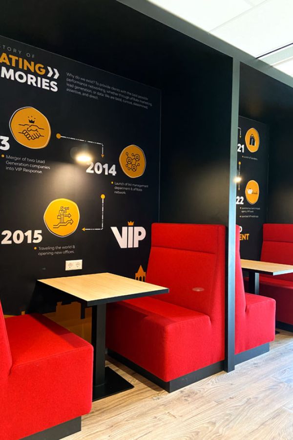 Kantoorinrichting van VIP in Utrecht met rode zitbanken en houten tafels