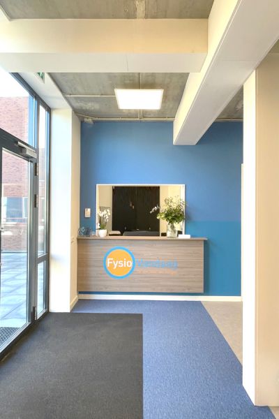 Inrichting fysiopraktijk FysioVandaag met moderne balie en blauwe accenten.
