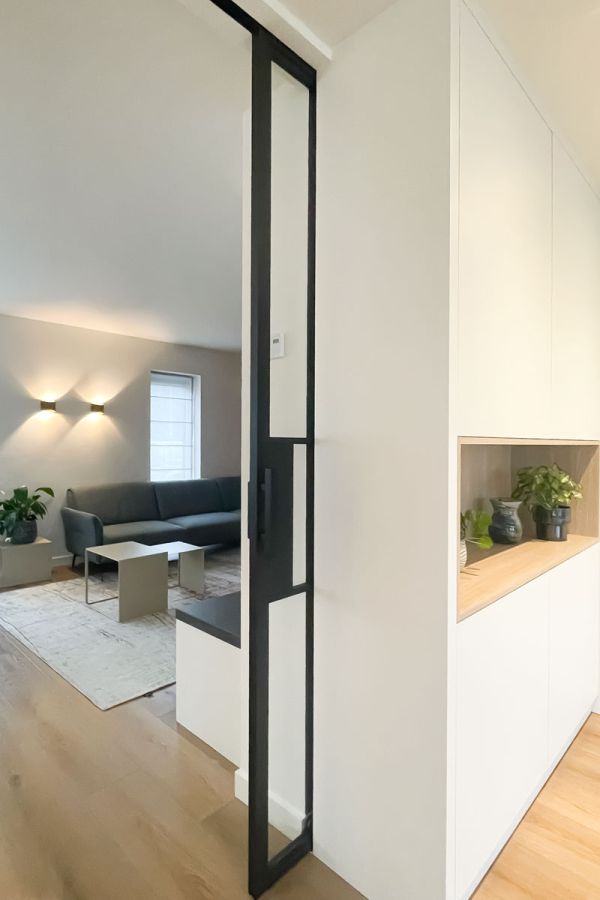 Modern interieur met stalen schuifdeur en maatwerk kast.