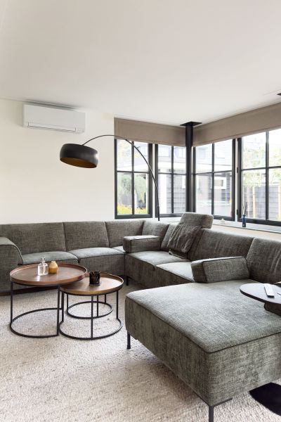 Stijlvolle woonkamer met hoekbank en zwarte kozijnen