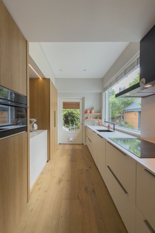 Een houten wandkast en beige kastdeuren in deze keuken op maat in Amersfoort