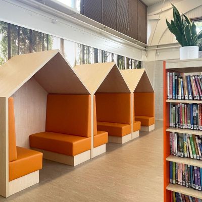 Gezellige huisjes met oranje treinbanken op het leerplein van een basisschool.