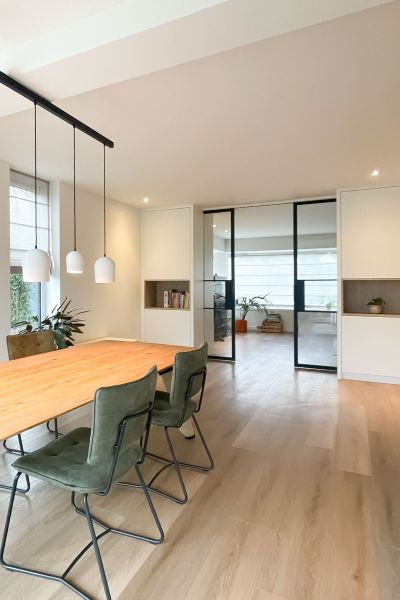 Inrichting woning met eettafel en stalen deur met kasten op maat