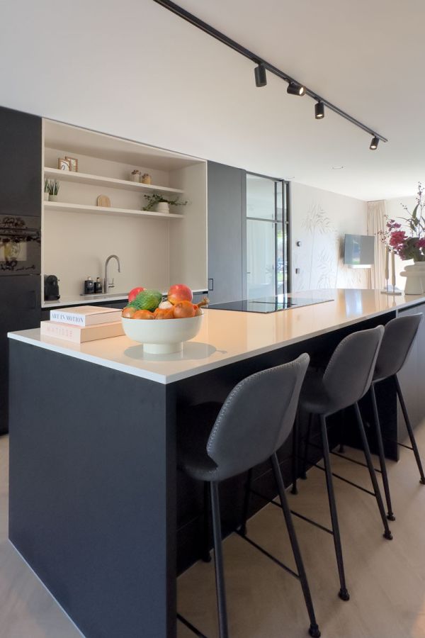 Zwarte keuken op maat met kookeiland en barkrukken in moderne houten woning