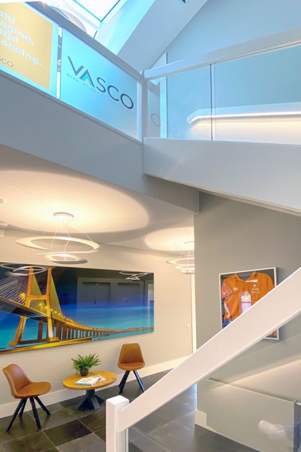 Monumentaal kantoorpand met moderne inrichting, open trap en glazen balustrade.