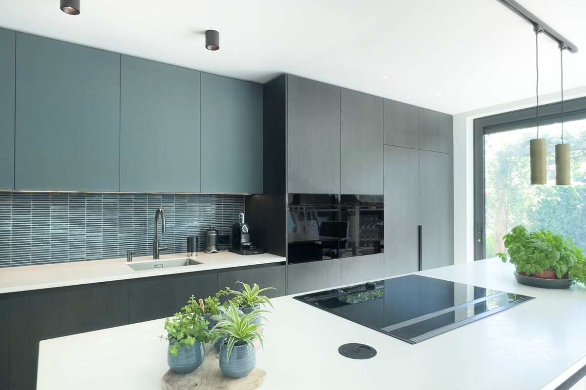 Moderne keuken op maat in Amersfoort met kookeiland en hoge kastenwand.