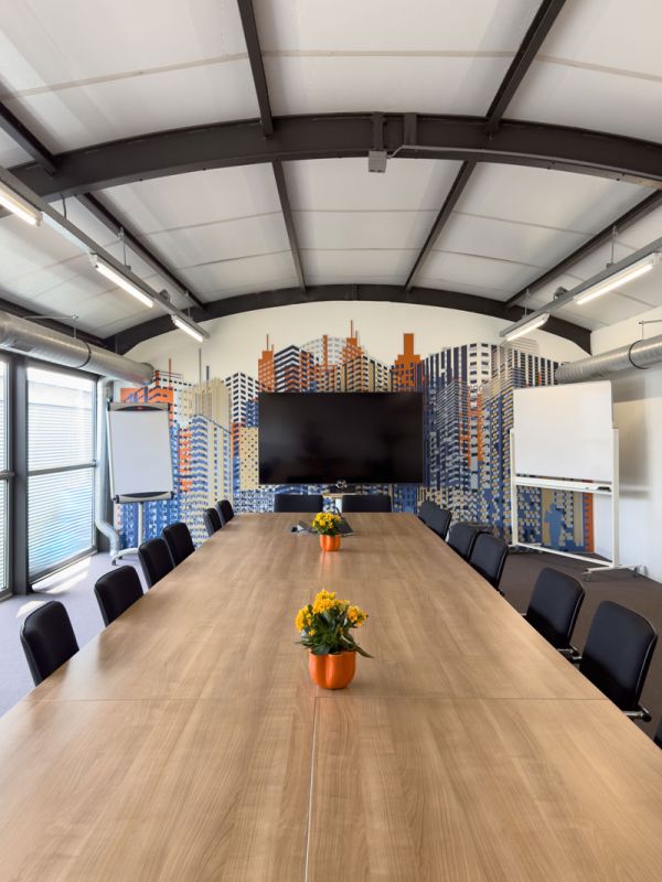 Grote vergaderzaal van het Condor-kantoor in Amersfoort met lange vergadertafel, stalen spantconstructie en skyline visual.