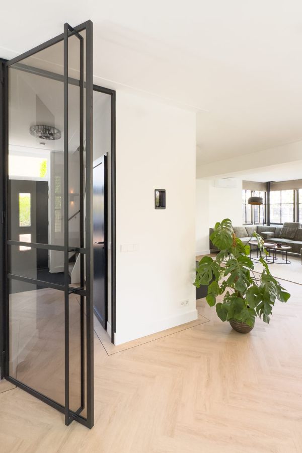 Luxe interieur met zwarte keuken en stalen deur