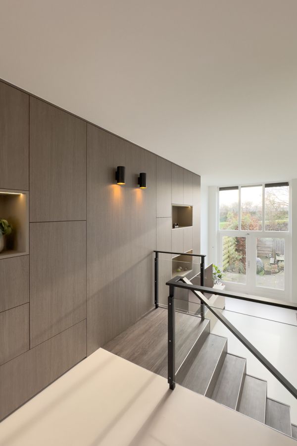 Maatkast met geïntegreerde verlichting en een moderne trapopgang in een woning in Amersfoort, ontworpen voor een stijlvolle en functionele indeling.