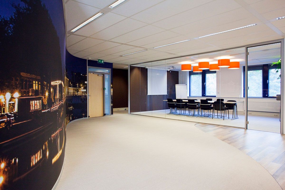 Modern kantoor in Zeist met oranje hanglampen in de vergaderkamer.