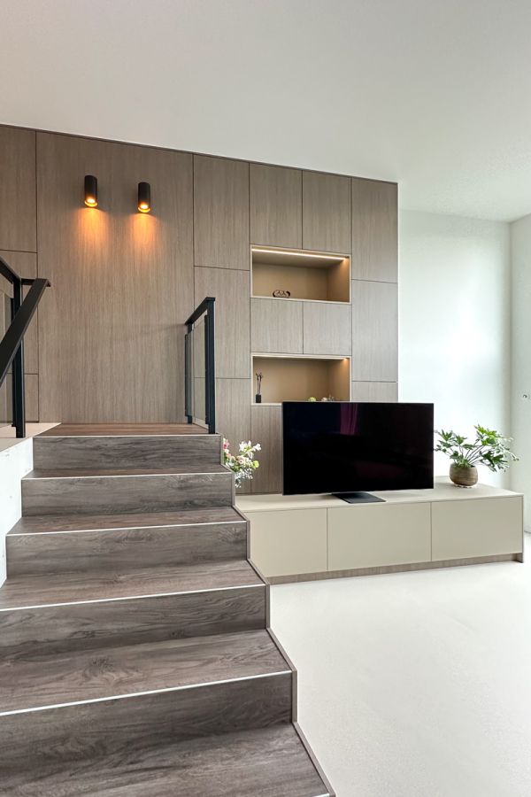 Stijlvol interieur op maat met een trap en tv-meubel geïntegreerd in een maatkast, ontworpen voor een moderne woonkamer in Amersfoort.