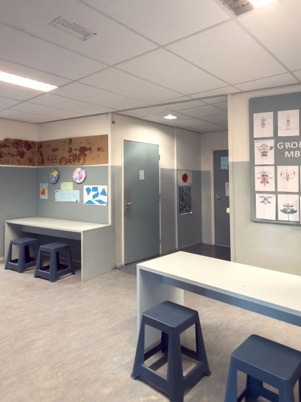 Concentratiewerkplekken in de gang met donkerblauwe krukken voor de schoolinrichting van basisschool Pallas Athene.