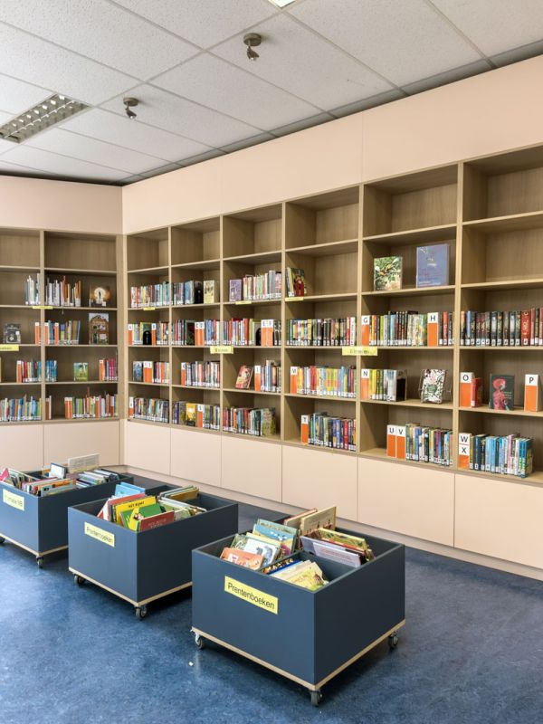 Bibliotheekkast met blauwe verrijdbare bakken met boeken in teamkamer.