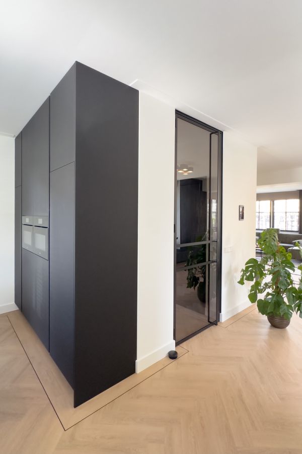 Luxe interieur met zwarte keuken en stalen deur