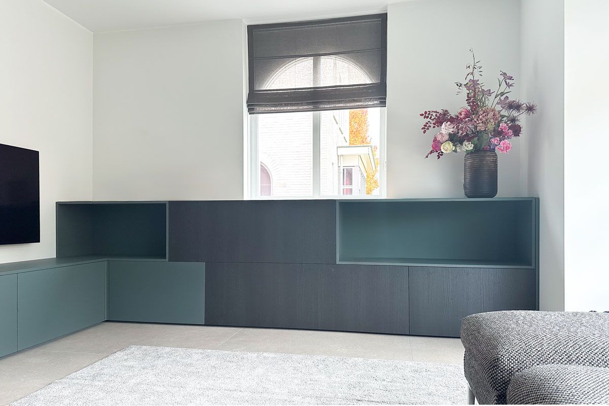 Maatwerk tv-kast onder raam in woning Amersfoort.