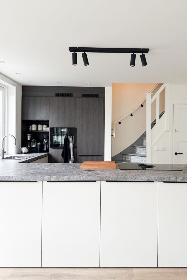 Moderne keuken in jaren 30 woning met grijs werkblad en ingebouwde apparatuur.