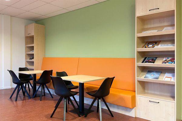 Lerarenkamer ingericht met kast op maat en kleurrijke zitbank