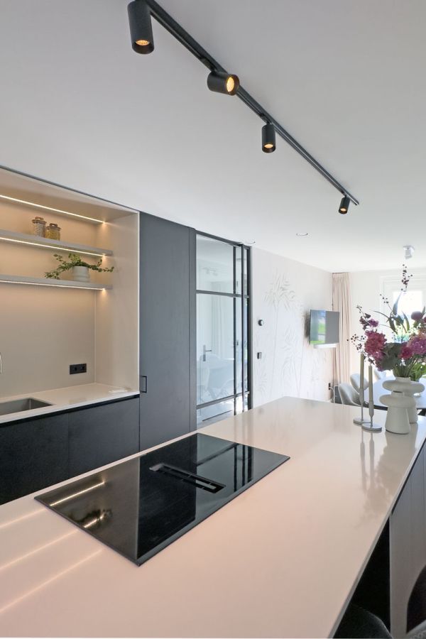 Interieur op maat met maatwerk keuken met zwart kookeiland en zwarte verlichting.