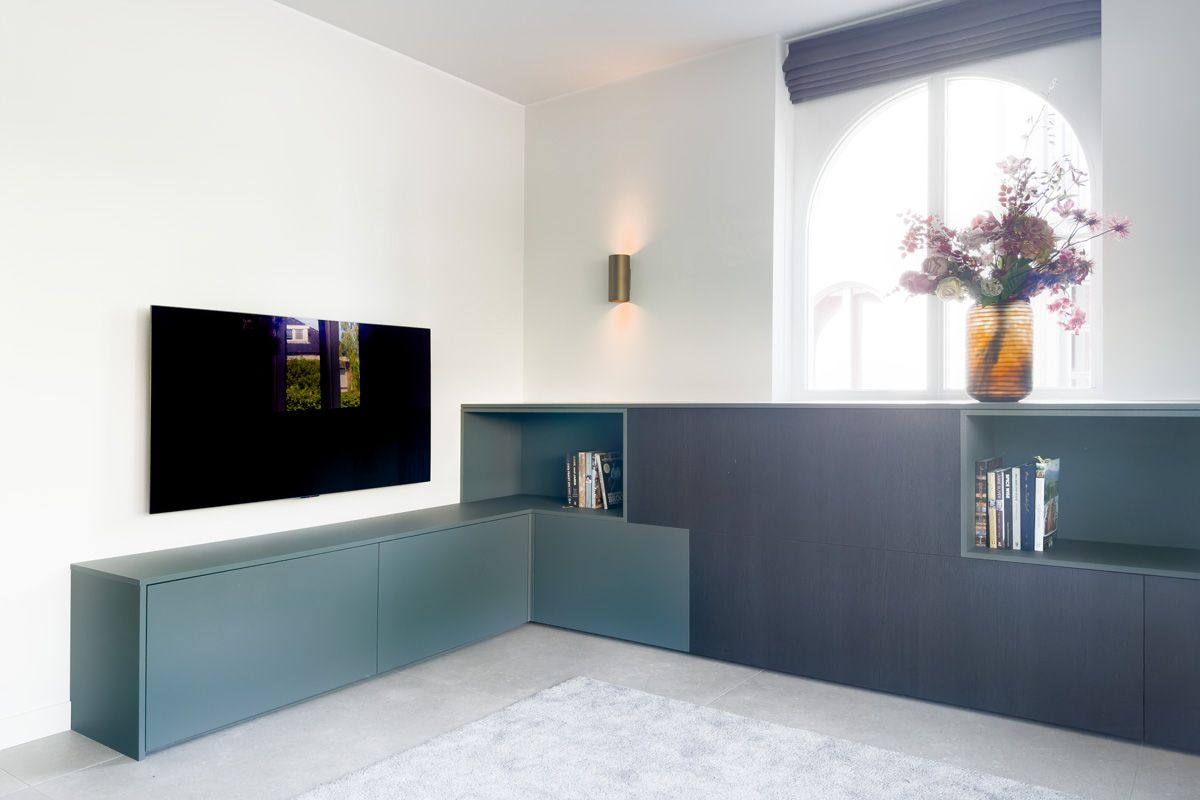 Tv-meubel op maat in woning Amersfoort met geïntegreerde boekenvakken.